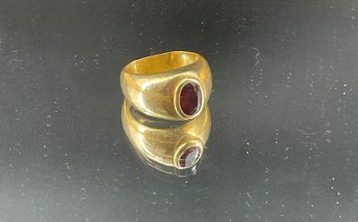a close up of a gold ring with two red stones