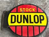 a sign that says stock dunlop on the side of a building