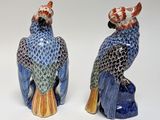 pair of blue and orange ceramic parrots sitting on top of each other