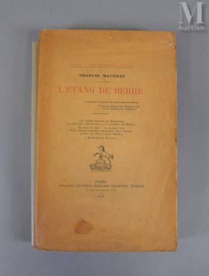 un vieux livre posé sur une table à côté d'un mur blanc