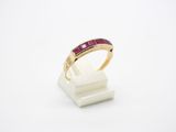 a close up of a gold ring with a ruby stone in it