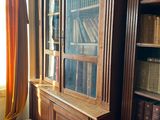 a bookcase with many books on it in a room