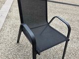 une chaise noire posée au milieu de la rue