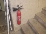un extincteur accroché au mur à côté de l'escalier