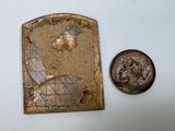 a coin and a piece of metal on a table