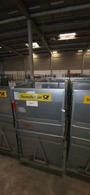 many metal bins in a warehouse with signs on them