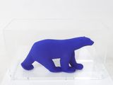 a blue polar bear in a clear box on a white surface