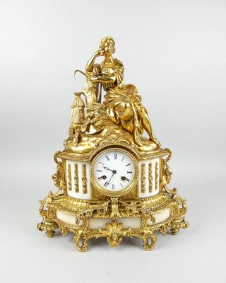 une horloge en or surmontée d'une statue