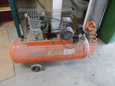 un petit compresseur d'air orange posé par terre