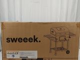 the box is open on the table with a grill on it
