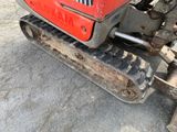 a close up of a small red tractor on the ground