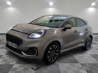 Une voiture argentée est garée dans une pièce au sol en damier