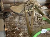 a green plow in the middle of a pile of hay