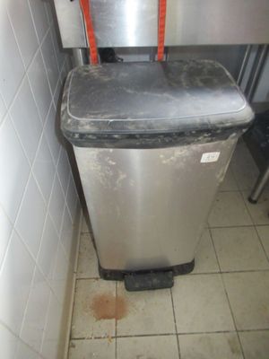 une poubelle dans un coin d'une cuisine sale