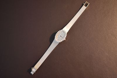 a watch that is laying on a brown surface