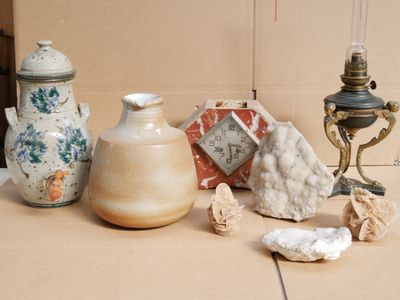 many different vases sitting on a table next to a lamp