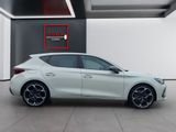 a white car is parked inside of a building with a red sign on the wall