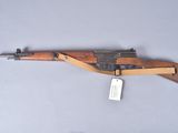 an old wooden rifle with a tag attached to it ' s side