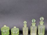 quatre bouteilles en verre vert avec leurs bouchons, posées sur une surface noire