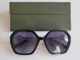 Les lunettes de soleil sont noires et ont des verres violets.