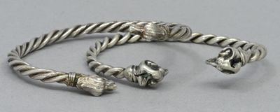 deux bracelets en argent posés sur une table, avec une perle en argent à l'extrémité