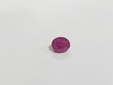 a close up of a pink stone on a white surface