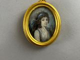 miniature portrait of a woman in a blue hat in a gold frame