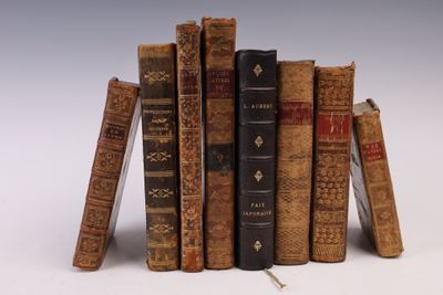 plusieurs vieux livres empilés sur une surface blanche