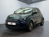 La petite voiture est garée dans une grande pièce aux murs blancs.