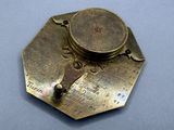 a brass plate with a clock on it on a table