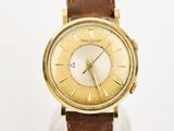 une photo d'une montre-bracelet en or avec un bracelet en cuir marron