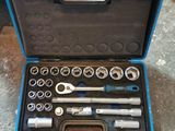 un jeu d'outils rangé dans une boîte à outils posée par terre