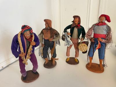 five figurines of people standing on a white surface