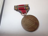 an old medal with a ribbon on a white surface