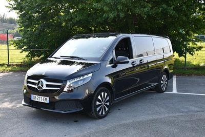 Une fourgonnette Mercedes Classe V garée sur un parking, avec des arbres en arrière-plan