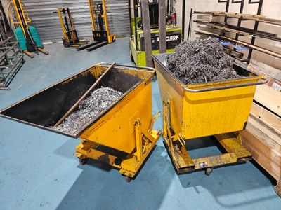 two yellow bins filled with metal items in a warehouse
