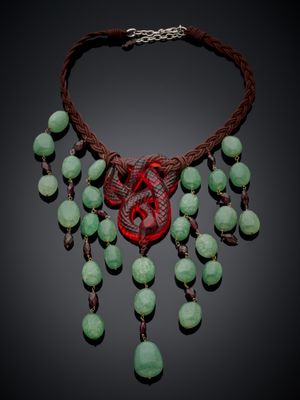 un gros plan d'un collier composé de perles vertes sur fond noir