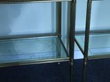 two tables with glass shelves on each side of them