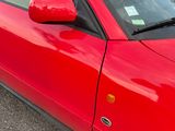 a red car that is parked in a parking lot
