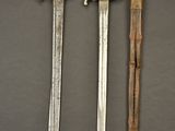 two old swords are sitting next to each other on a table