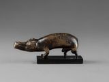 a small bronze figurine of a pig on a black base