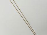 un collier plaqué or avec une pièce suspendue à une chaîne