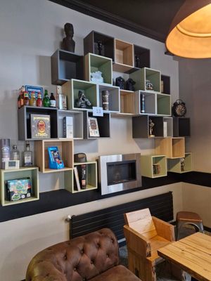 une pièce avec un canapé, une table, une chaise et des étagères au mur
