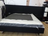 un lit sur lequel est posé un matelas dans une pièce