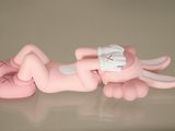 a pink figurine of a baby laying on its back