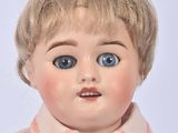 a close up of a doll with blue eyes