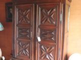 a wooden armoire in the corner of a living room