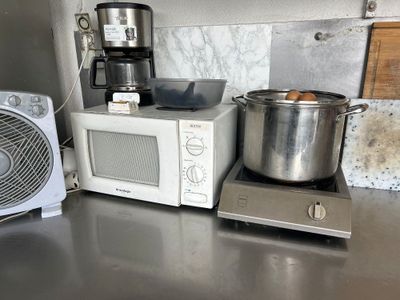 un micro-ondes et une casserole posés sur un plan de travail dans une cuisine