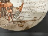 a plate with a drawing of a man sitting in a chair