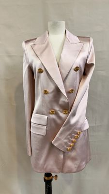 pink jacket with gold buttons on a mannequin base